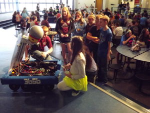 A group of kids looking at a robot.