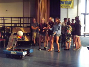 A group of girls interacting with a robot.