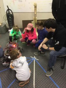 a group of young kids get a up close look at the robot