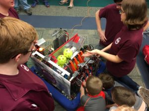 kids looking closely at a robot