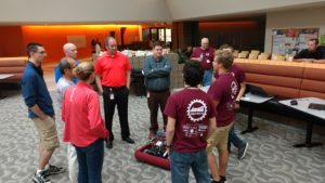 A group of employees looking at our robot